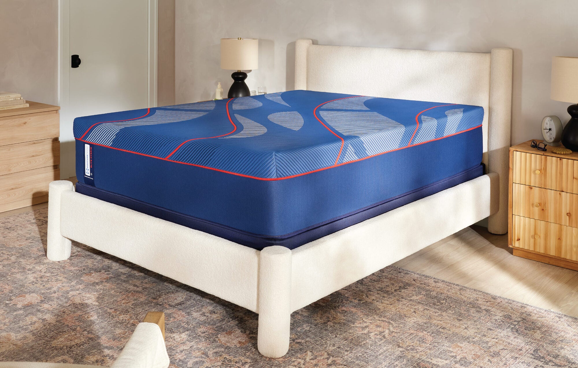A Sealy Posturepedic Elite mattress on a low bed frame in a sunlit bedroom